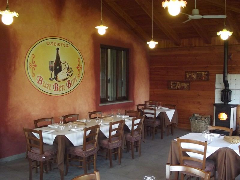 La sala in legno con l'insegna dell'osteria e la stufa
