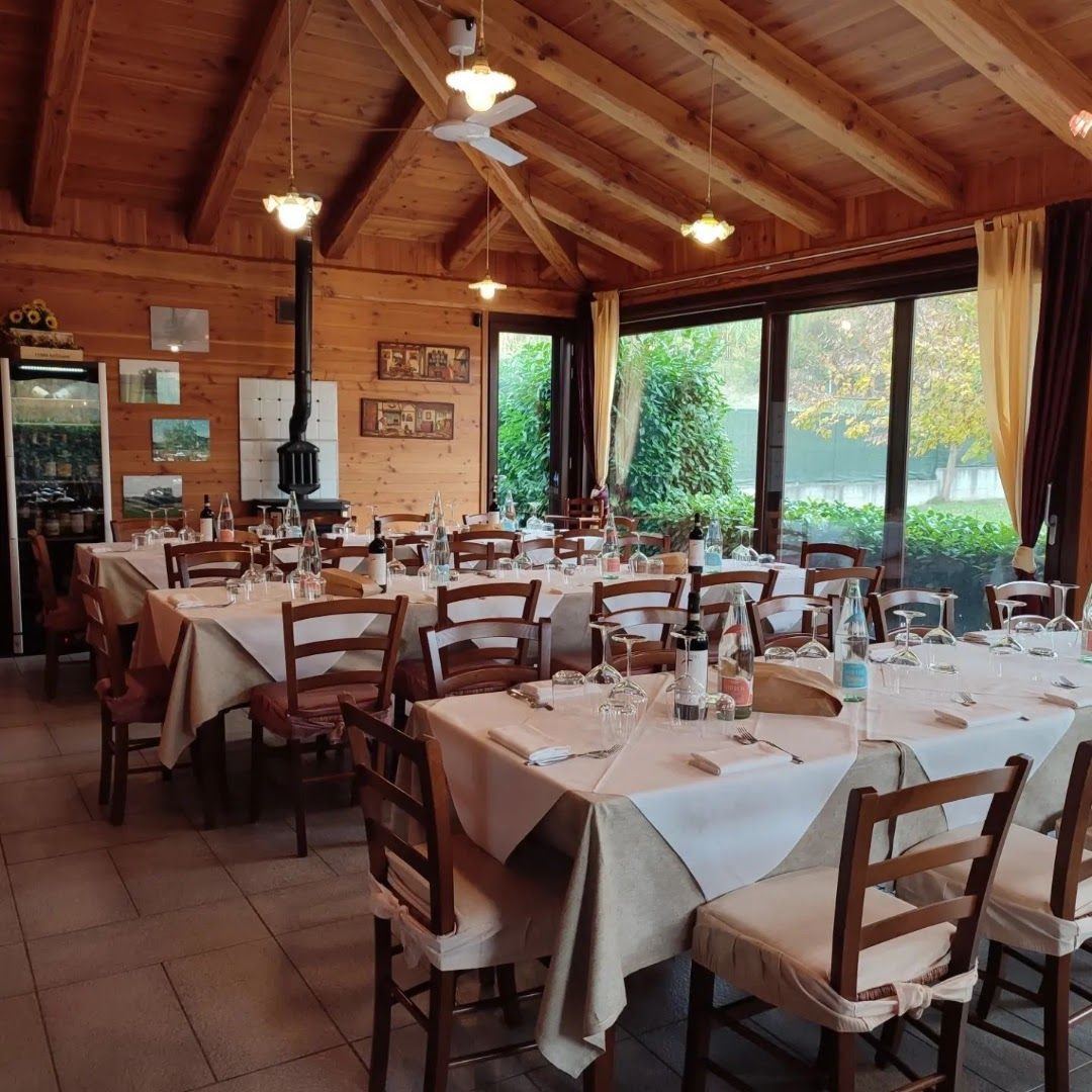 La veranda con le vetrate sul giardino e i tavoli apparecchiati